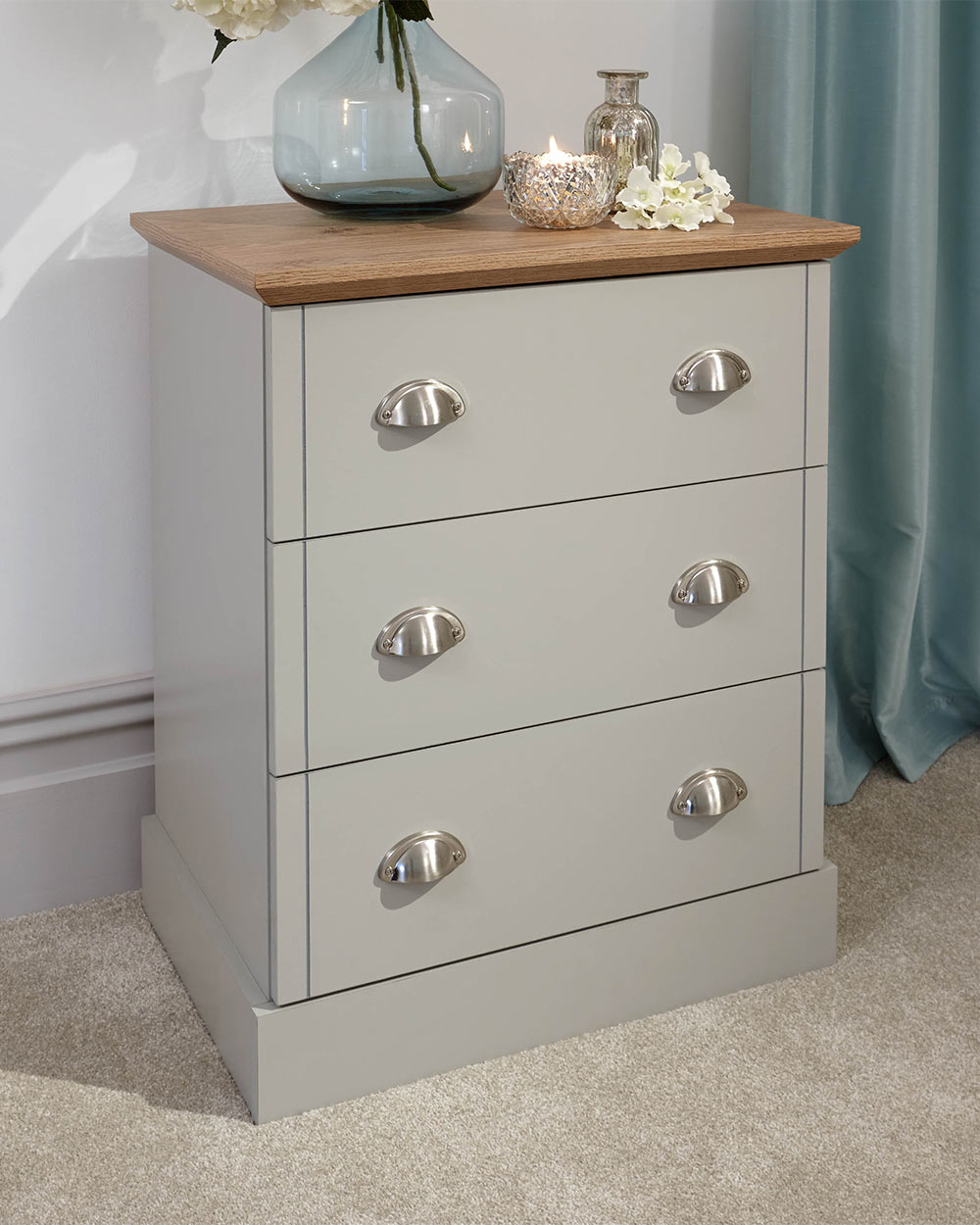A modern grey chest of drawers with 3 drawers. Generous storage space for clothes and accessories. Features brushed steel cup handles and easy glide metal runners. Sturdy structure with a bevelled oak-effect top. Flat packed for home assembly. Perfect for adding a personal touch to your room.