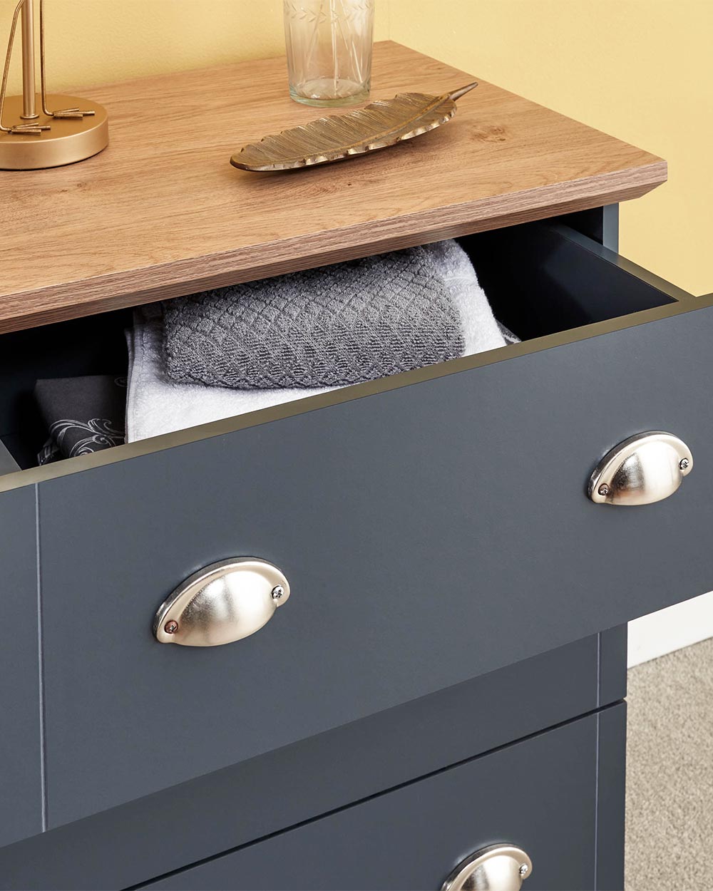 A modern grey chest of drawers with 3 drawers. Generous storage space for clothes and accessories. Features brushed steel cup handles and easy glide metal runners. Sturdy structure with a bevelled oak-effect top. Flat packed for home assembly. Perfect for adding a personal touch to your room.