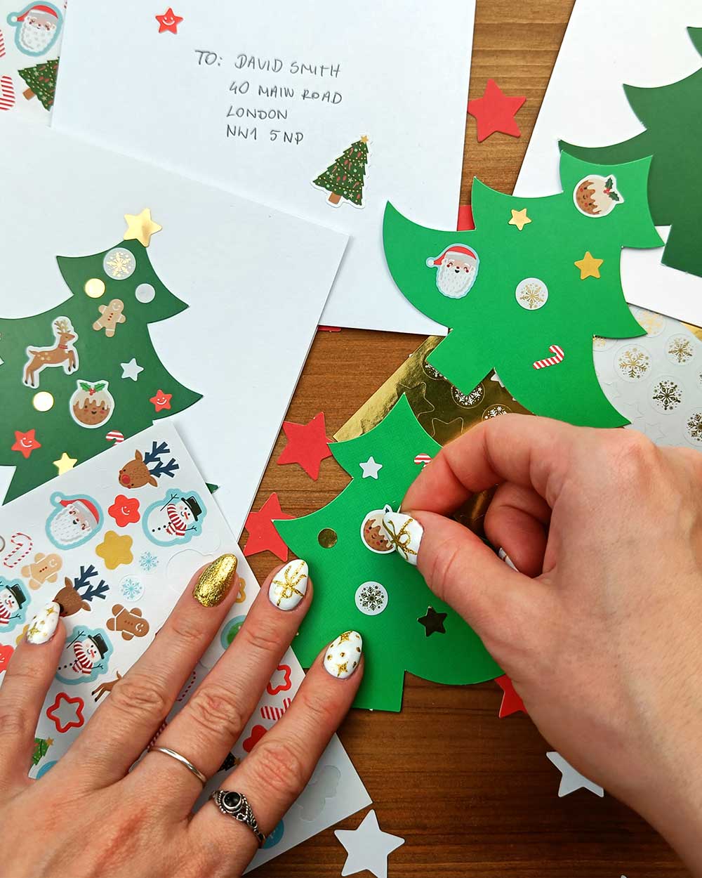 nside this kit, you'll find 10 high-quality Christmas tree-shaped cards. With 5 light green and 5 dark green trees, you'll have the perfect canvas to create stunning, personalised cards. Accompanying these charming cards are 10 white envelopes, ensuring your heartfelt creations have the perfect finishing touch. With an array of 140 jolly festive stickers, from candy canes to gingerbread men, snowmen to Santa Claus, reindeer to presents and more! and 110 gold stickers