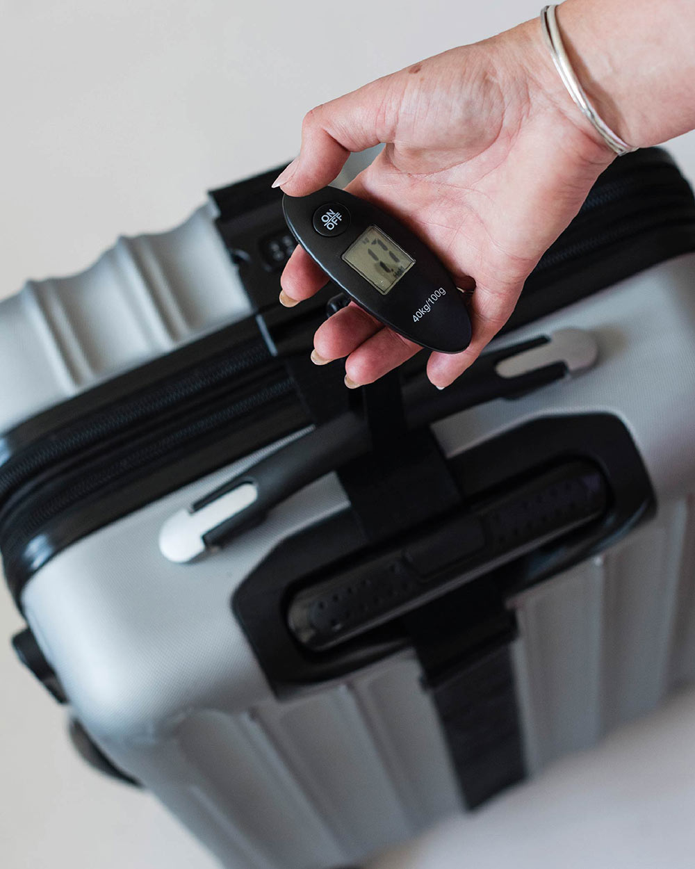 luggage scales Navig8 black electronic. Suitcase being weighed, lifestyle image