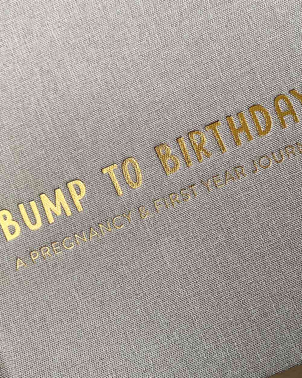 Capture and journal your pregnancy, birth and up until your baby's 1st Birthday with this lovely memory book. Helping you hold onto memories in a wonderful keepsake book with room to write, add in photos to tell your own story. Close up of the grey fabric and gold foiling detail