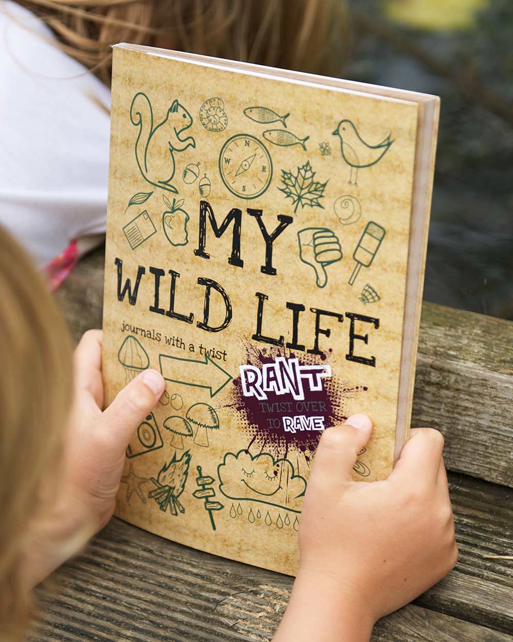 Kids Activity Book Rant & Rave, About My Wild Life. Lifestyle image of a child holding the book outdoors