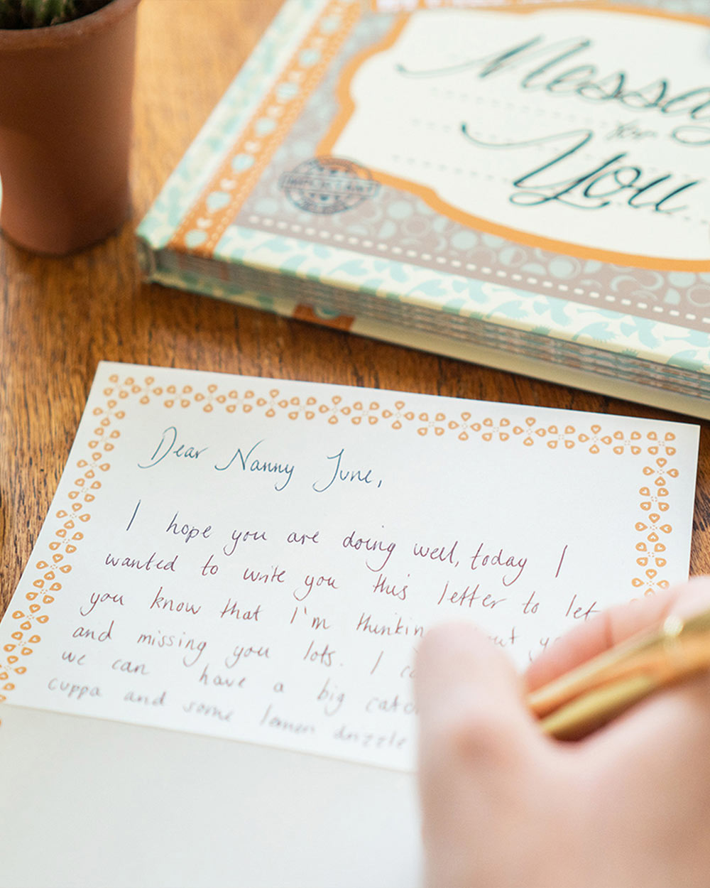 Keepsake Book Messages For You, While You’re Away. Lifestyle image of someone writing a message.