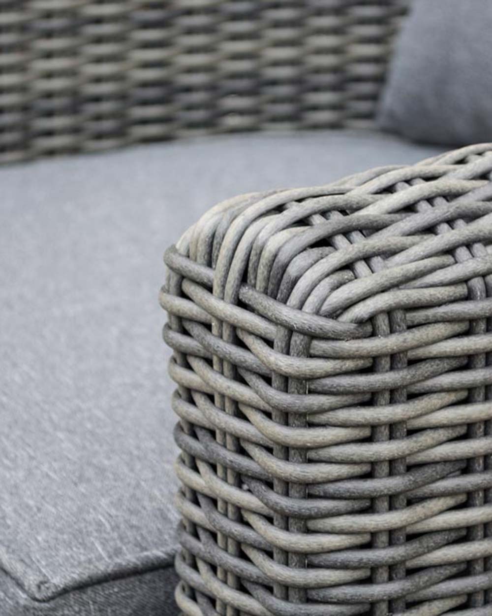 close up of the rattan furniture set displayed on a patio close up of the rattan curved arm on the chair