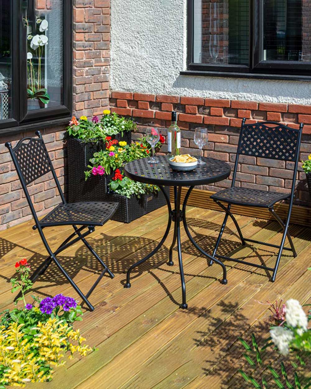 garden bistro set black matt lattice pattern Havana Rowlinson. Photo in a garden setting with a bottle of wine and snacks on the table