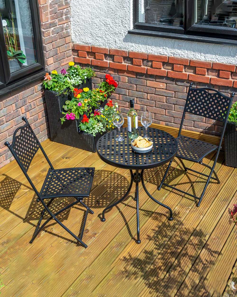 garden bistro set black matt lattice pattern Havana Rowlinson. Photo in a garden setting with a bottle of wine and snacks on the table