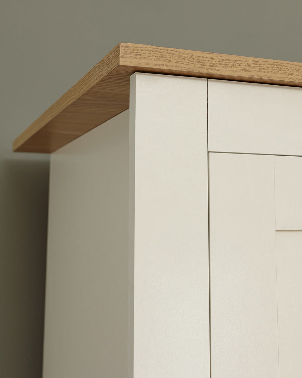 Lancaster shaker style wardrobe in cream with an oak effect top. Displayed in a bedroom setting, zoomed in on the oak effect top