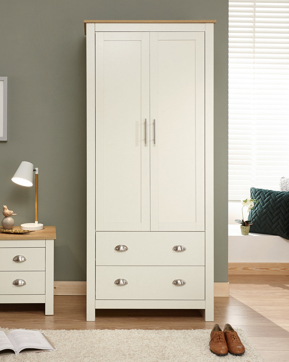 Lancaster shaker style wardrobe in cream with an oak effect top. Displayed in a bedroom setting