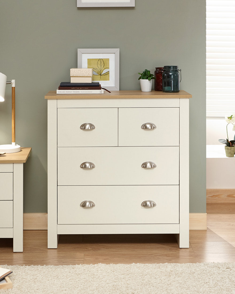 Lancaster 2 + 2 chest of drawers in cream with an oak effect top in a lifestyle setting in a bedroom