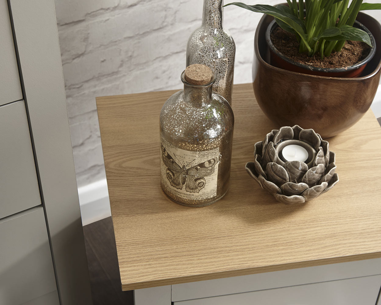 Lancaster 3 Piece Bedroom Furniture Set Grey lifestyle image in a bedroom. Close up image of the bedside table oak effect top