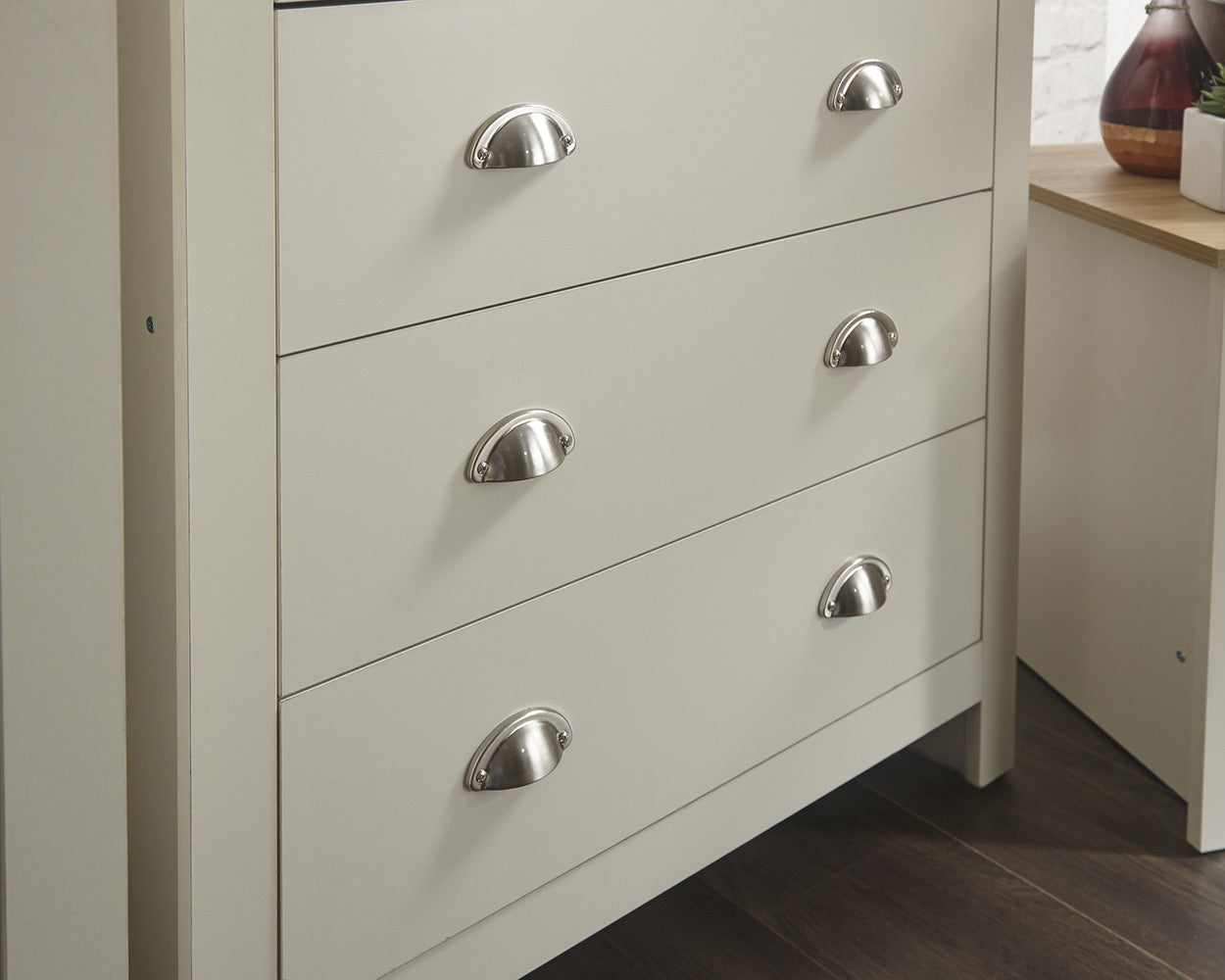 lancaster 3 piece bedroom set in cream with oak effect tops close up of the chest of drawer handles a lifestyle setting
