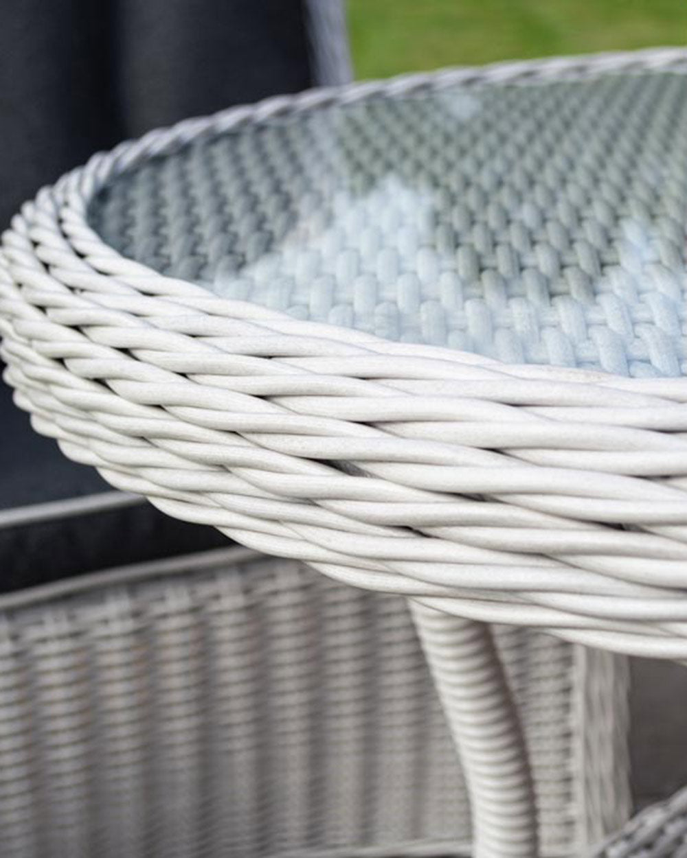 rattan bistro set weather proof in a garden setting, close up of the table edging and the glass table top