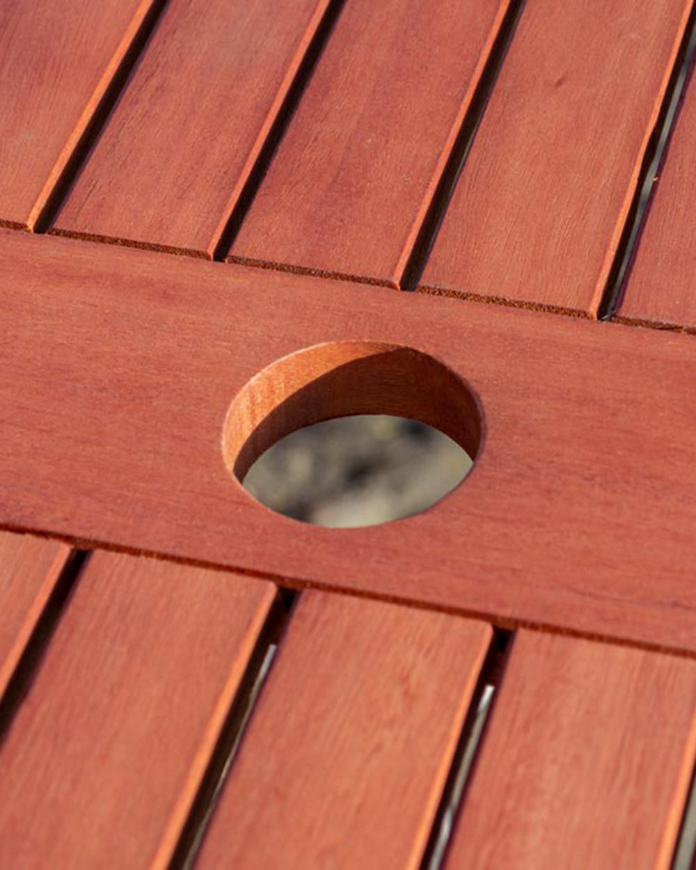 close up of this wooden garden table's parasol hole in the centre