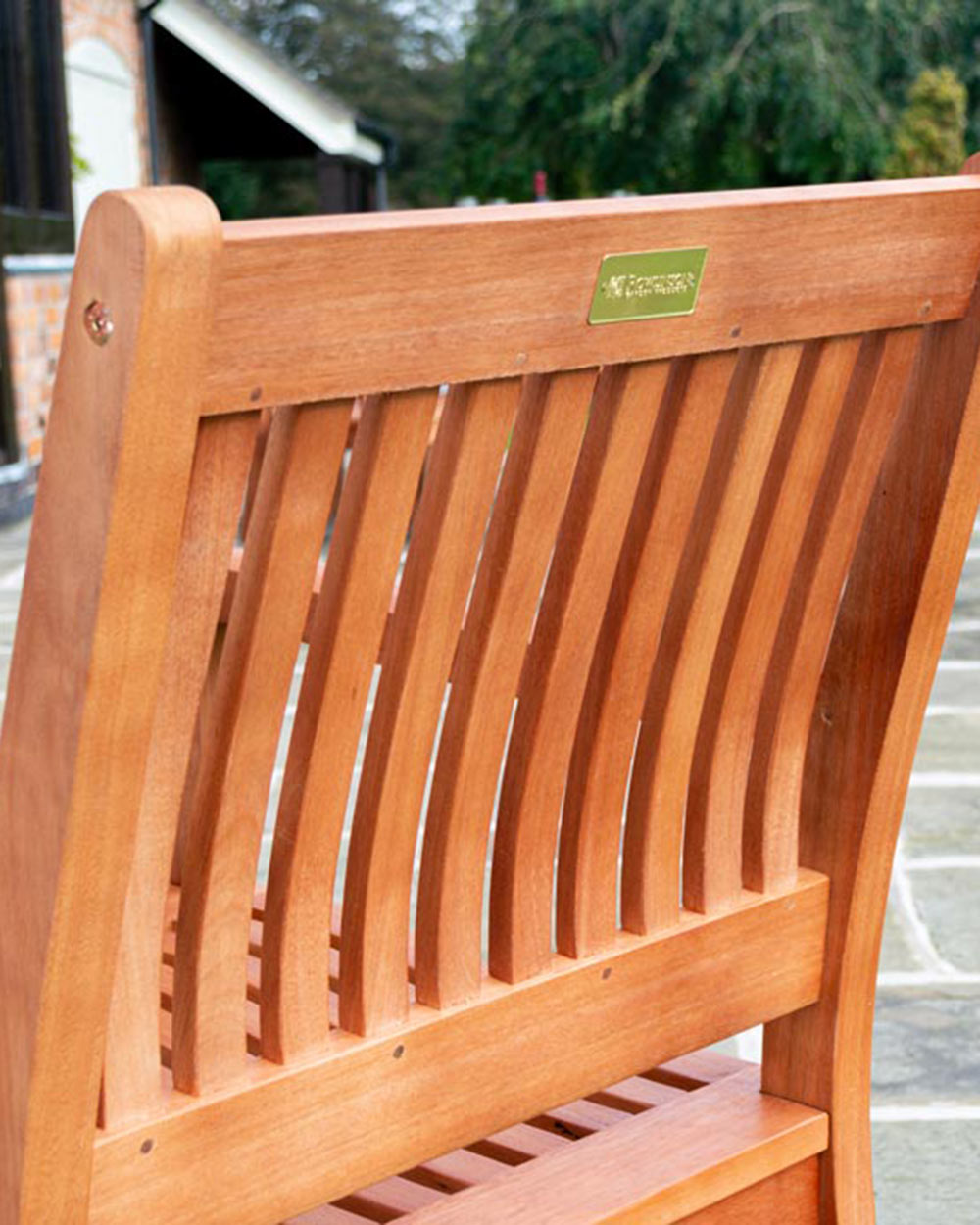 close up lifestyle image of  the garden furniture set armchair backrest with the Rowlinson badge on the back