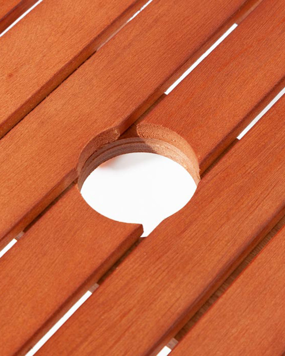 wooden garden table, close up of the parasol hole in the slats in the middle of the table