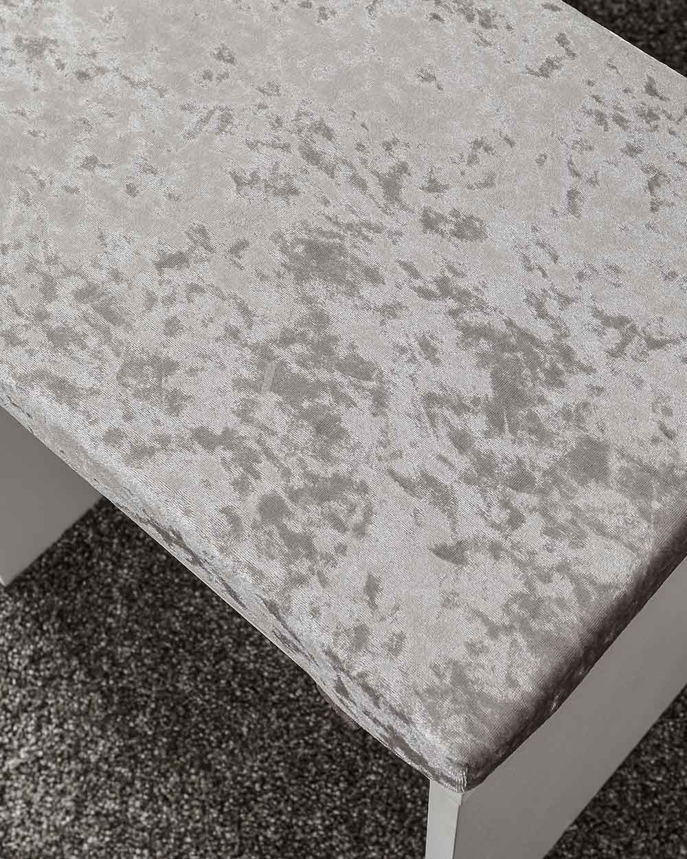 close up of the padded seat on the stool, with a crushed velvet effect upholstery