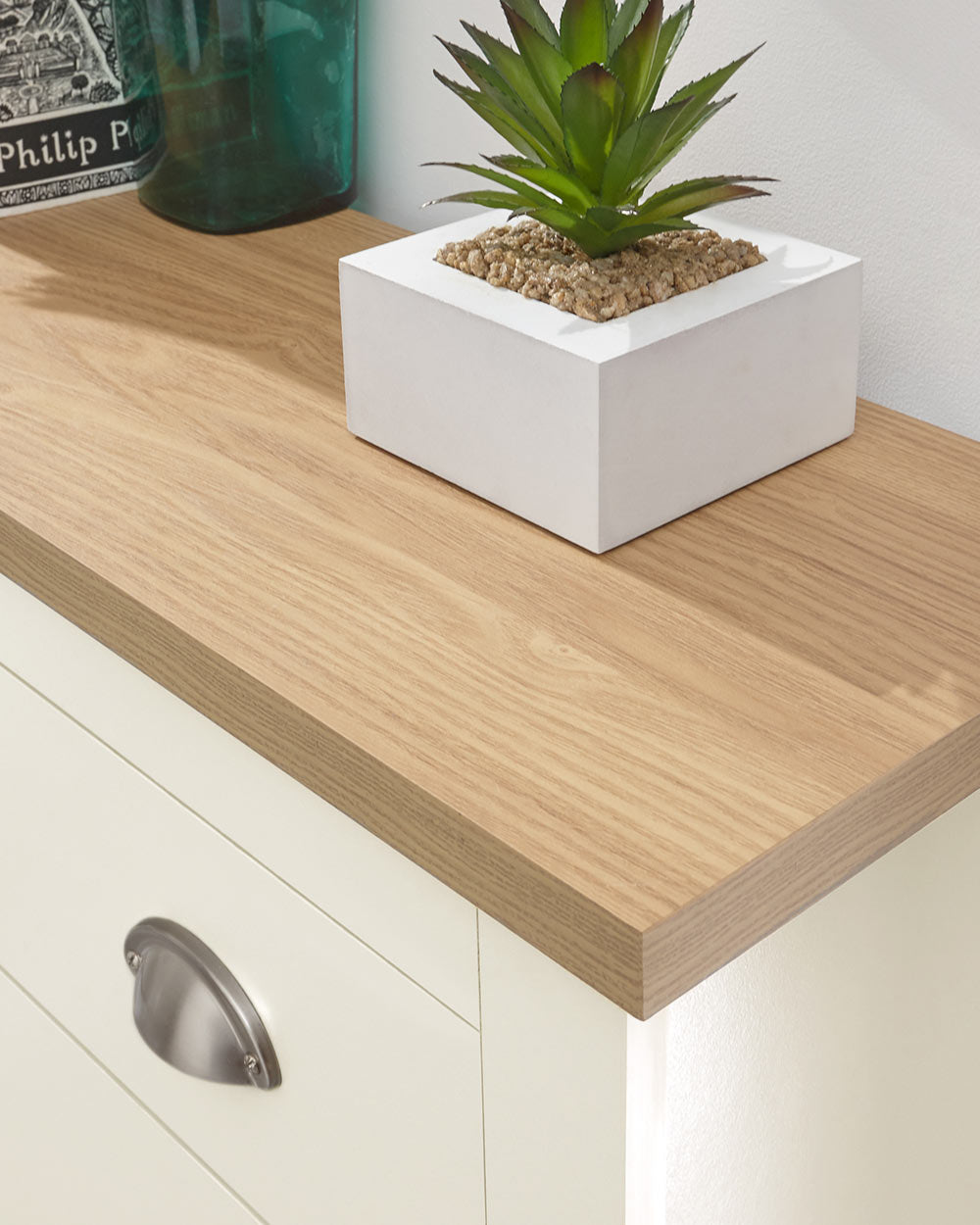 lancaster shoe storage cabinet in cream in a lifestyle setting. close up of the oak veneer top