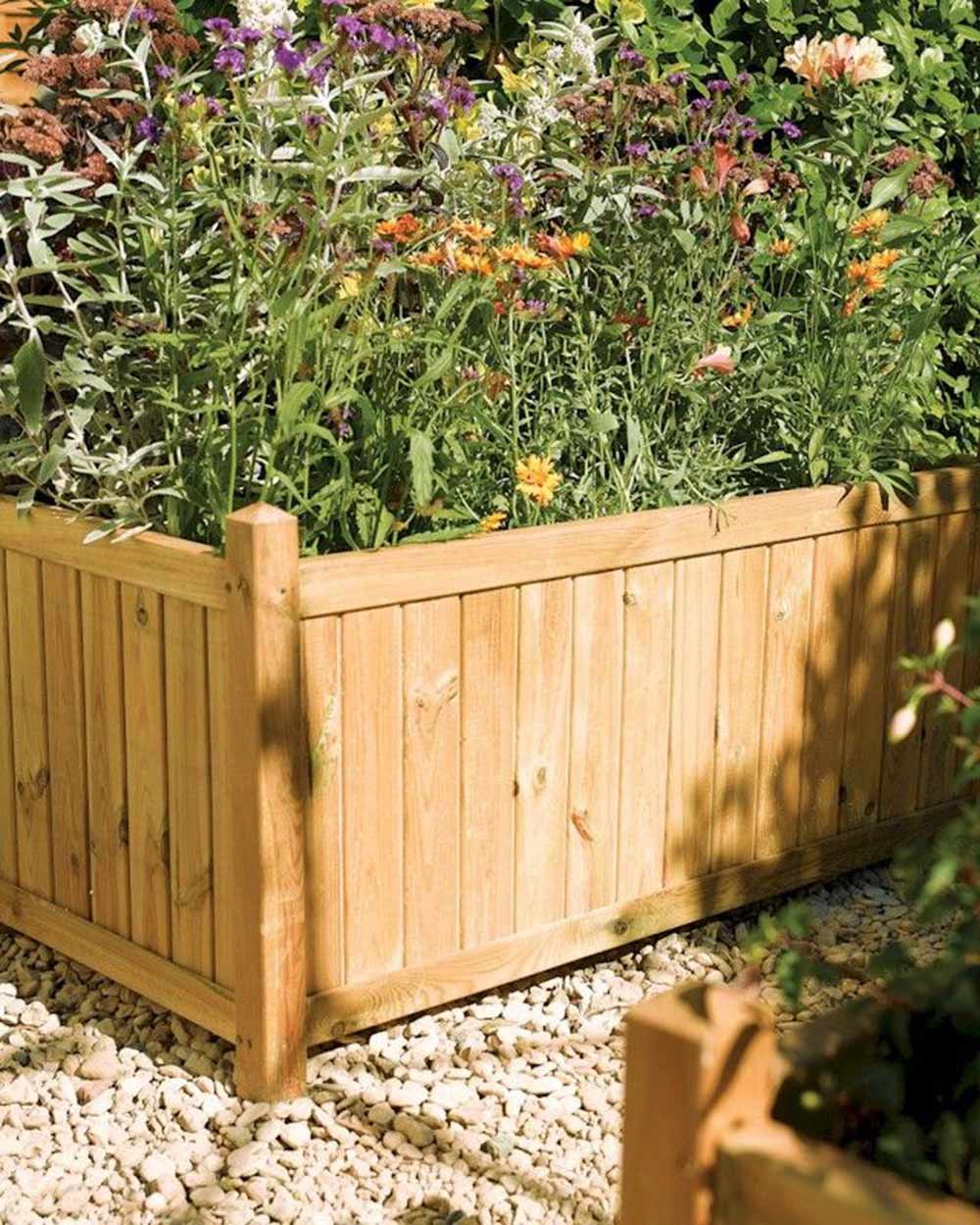 Rectangular Wooden Garden Planter Rowlinson in a garden with an array of plants inside