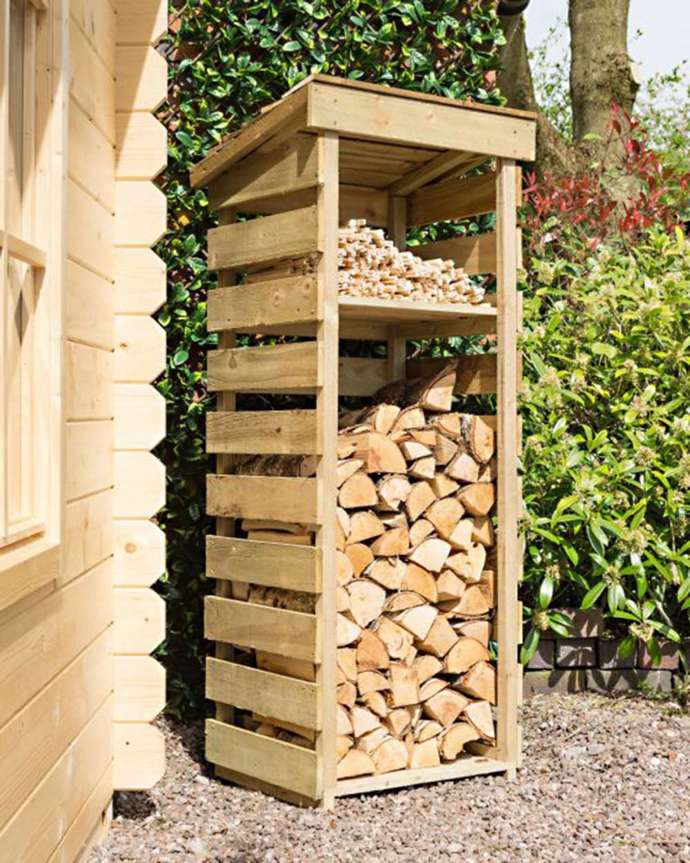 Slim log store narrow outdoor storage for wood kindling. Photographed in the garden with wood and kindling stored inside.