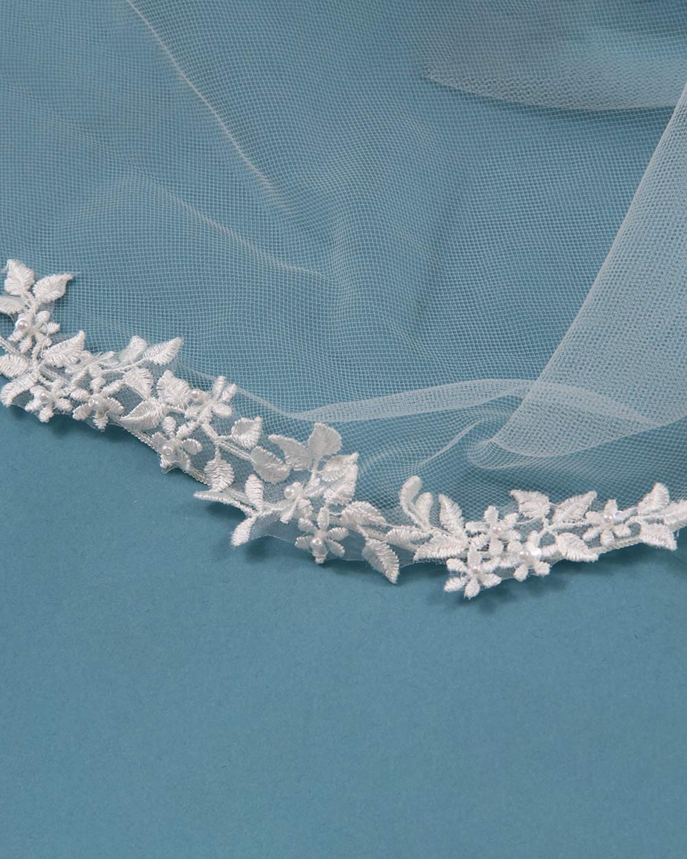 Lend a fabulous floral touch to your bridal look with this beautiful wedding veil. This delicate ivory tulle wedding veil is embellished with a floral lace motif edge.