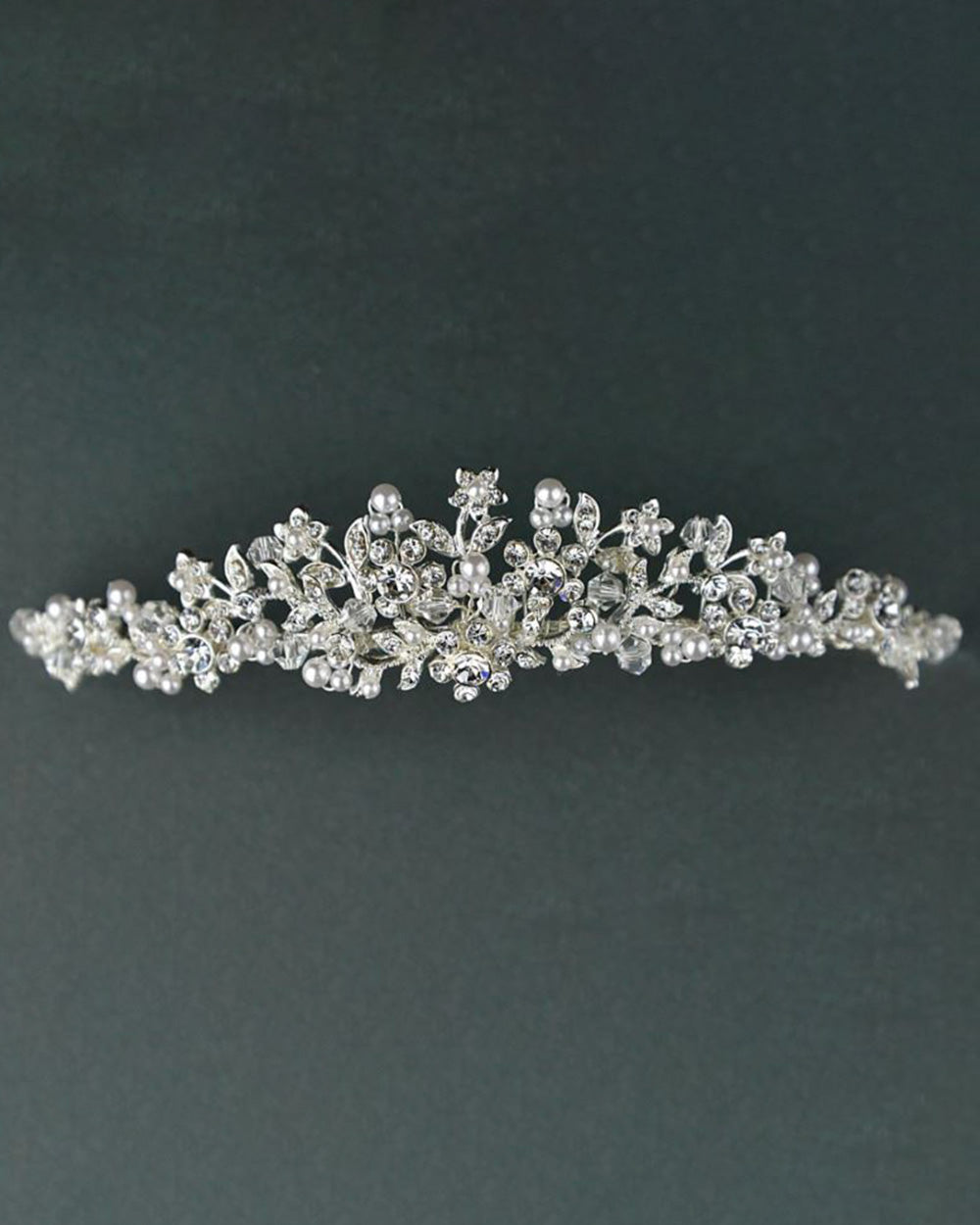 This diamante wedding tiara oozes sophistication and effortless style. Highly detailed with crystals and diamantes to create floral and leaf shapes. Decorated with stunning pearl beads for a classy and timeless design.  Why not take advantage of any and all chances to wear a tiara. If you can't wear one on your wedding day, when can you? Every bride deserves to feel like a true princess on their big day. So, complete your bridal look with one of our beautiful wedding tiaras.
