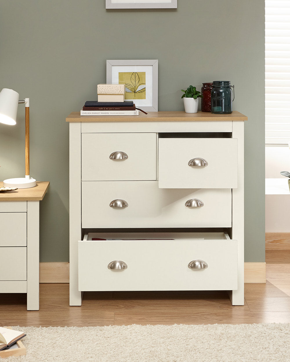 Lancaster 2 + 2 chest of drawers in cream with an oak effect top in a lifestyle setting in a bedroom with the drawers open