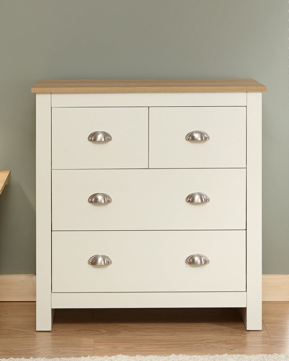 Lancaster 2 + 2 chest of drawers in cream with an oak effect top in a lifestyle setting in a bedroom