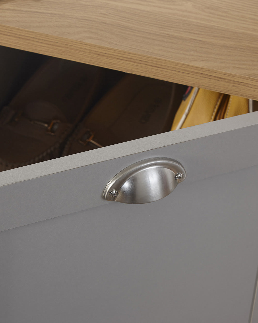 Lancaster shoe storage lifestyle inside a hallway setting. Grey with an oak effect top a close up of the brushed silver handles