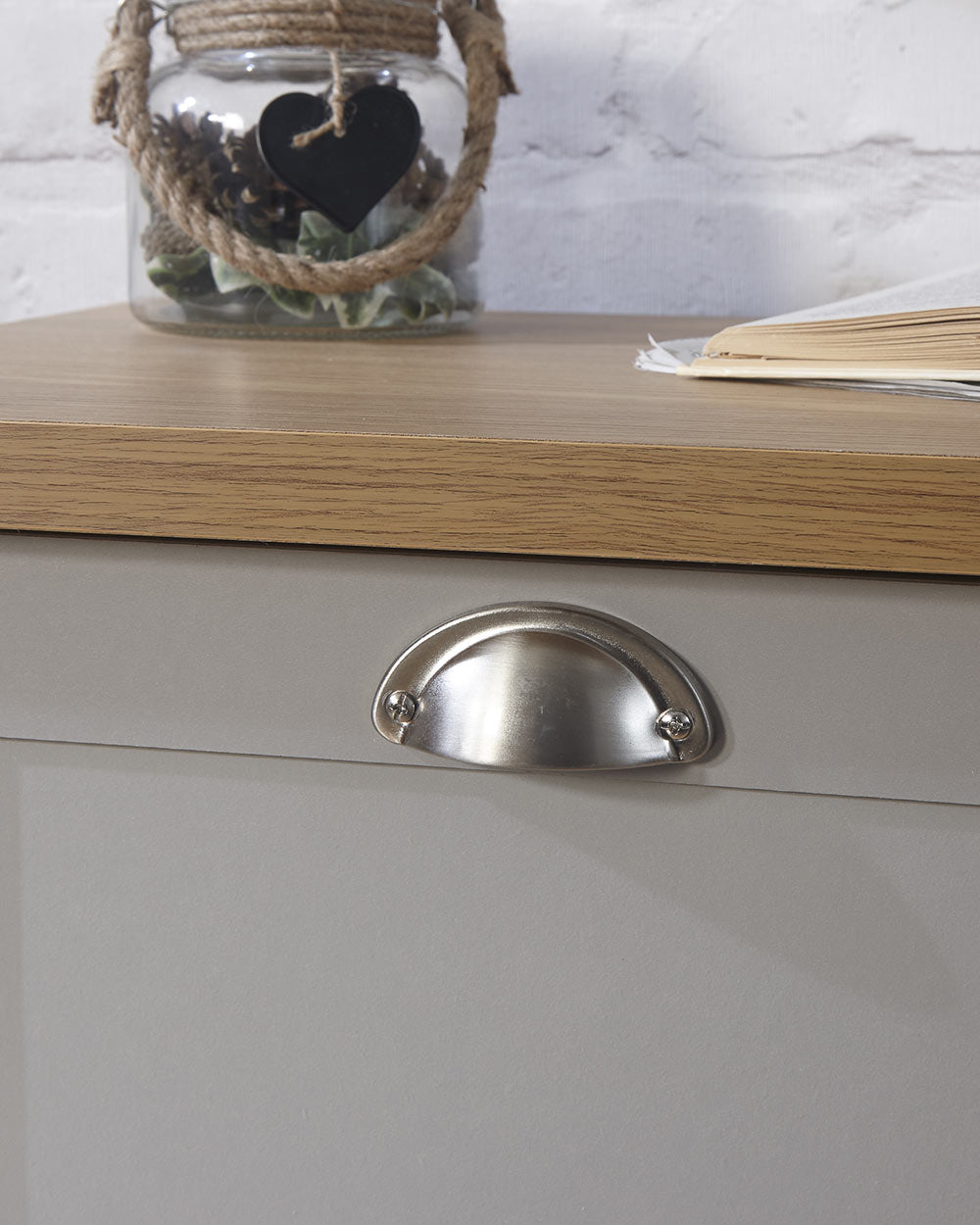 Lancaster shoe storage lifestyle inside a hallway setting. Grey with an oak effect top a close up of the brushed silver handles