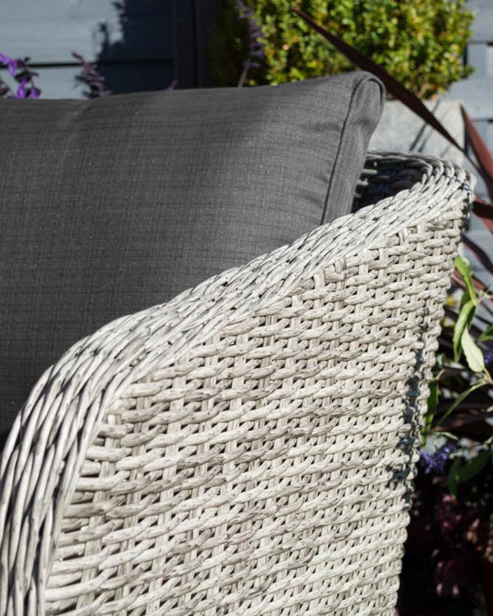 rattan garden furniture sofa set displayed in a garden with a jug of juice and glasses on the hardwood table close up of the arm chair rattan